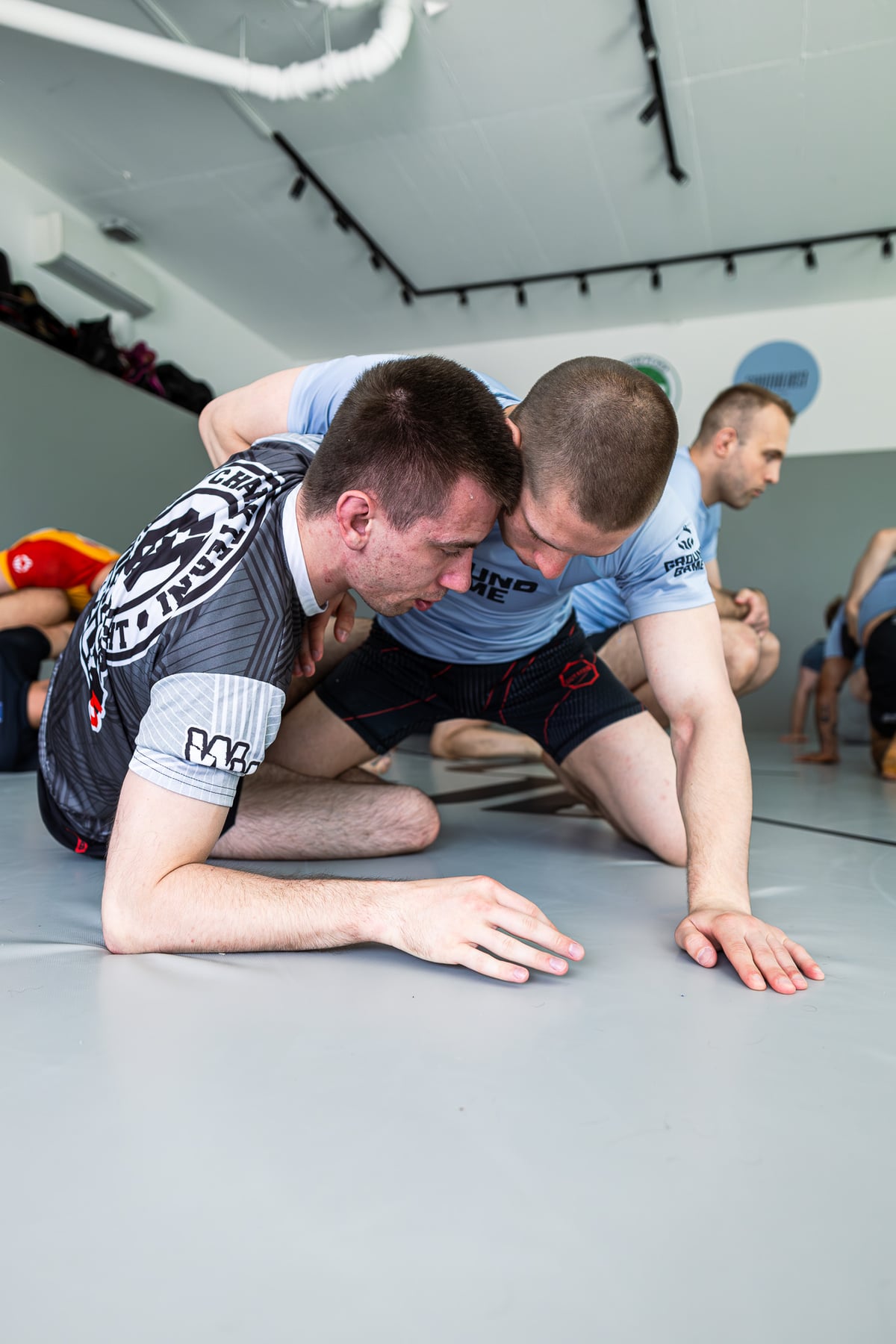 Dwaj klubowicze ćwiczący technikę Jiu-Jitsu na macie w Southeast